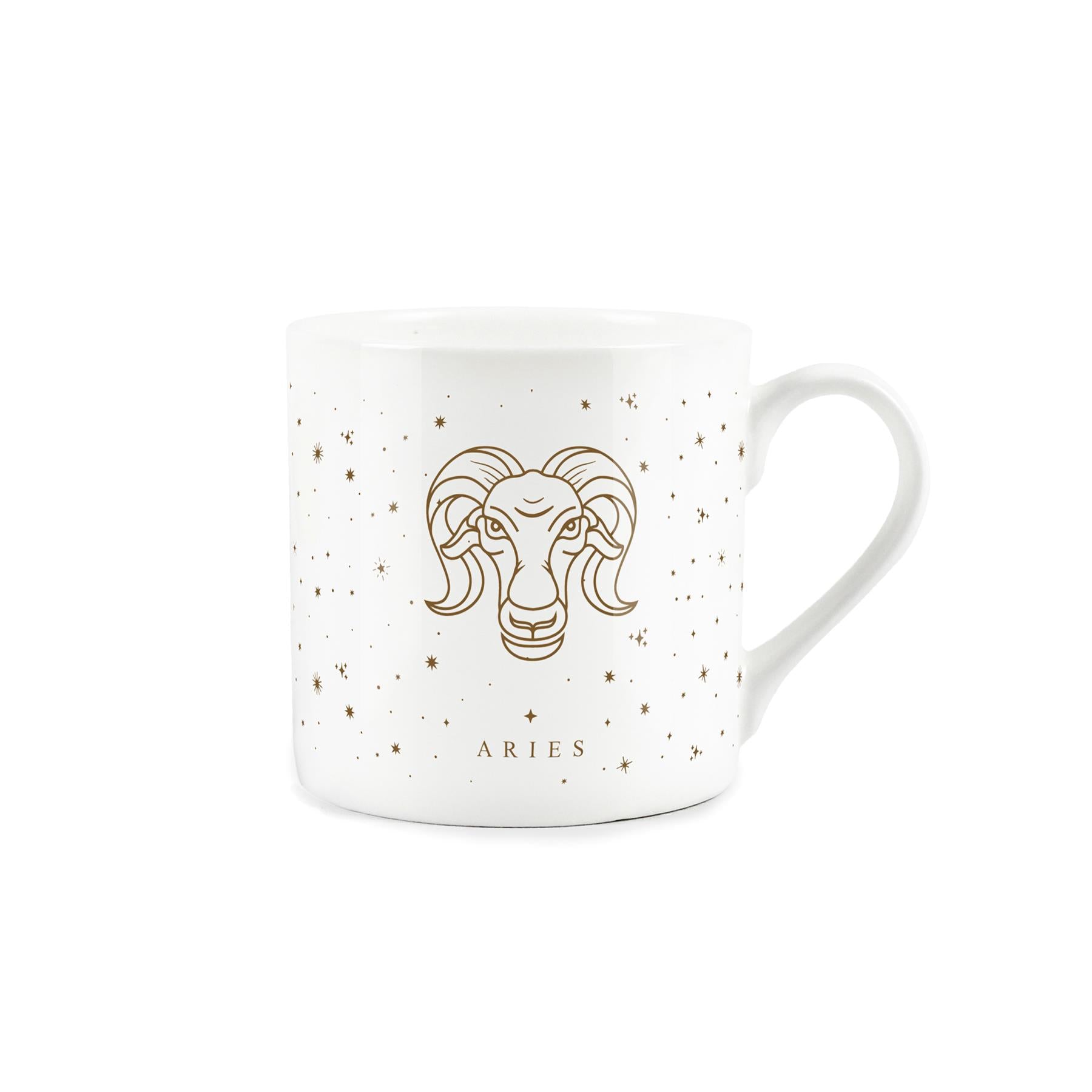 A white mug adorned with a golden zodiac design: aries