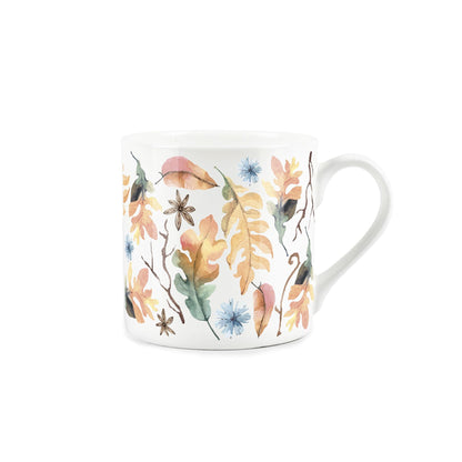 watercolour depiction of autumnal leaves, seed, and flowers on a white bone china mug 